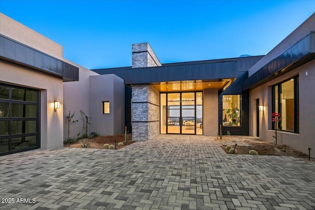 view of exterior entry with stone siding and stucco siding