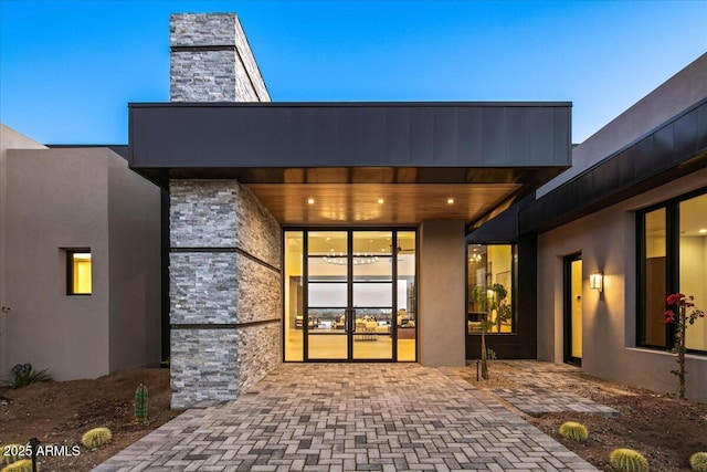 entrance to property with stone siding and stucco siding