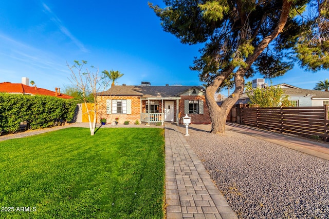 ranch-style house with a gate, brick siding, fence, and a front lawn