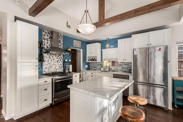 kitchen with vaulted ceiling with beams, stainless steel appliances, dark wood-style flooring, visible vents, and wall chimney range hood