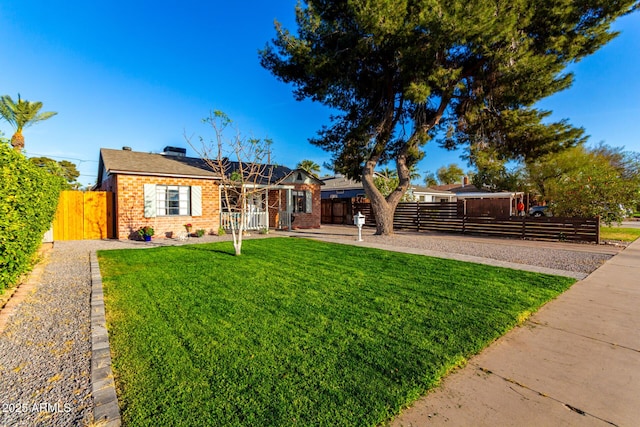 ranch-style home with fence private yard, a gate, a front lawn, and brick siding