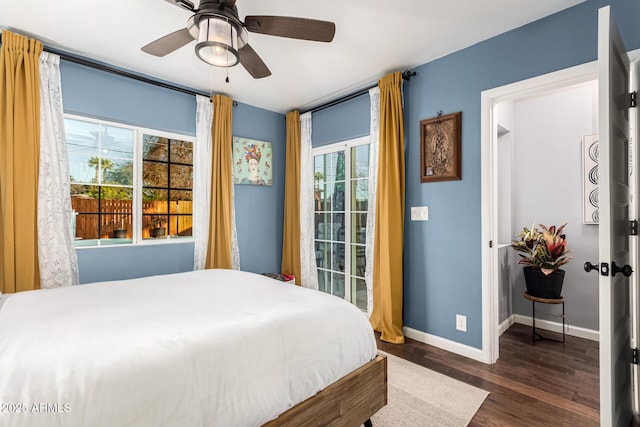 bedroom with multiple windows, dark wood finished floors, baseboards, and ceiling fan