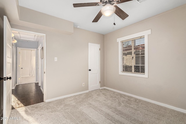 unfurnished bedroom with attic access, carpet, ceiling fan, and baseboards