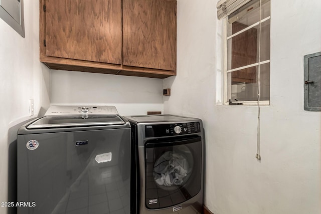 clothes washing area featuring separate washer and dryer and cabinet space