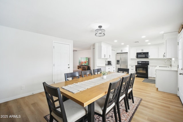 dining space featuring light wood finished floors, baseboards, and recessed lighting