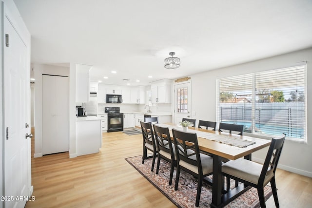 dining space with recessed lighting, light wood-style flooring, and baseboards