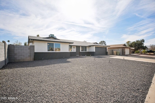 view of front facade with brick siding, fence, driveway, and an attached garage