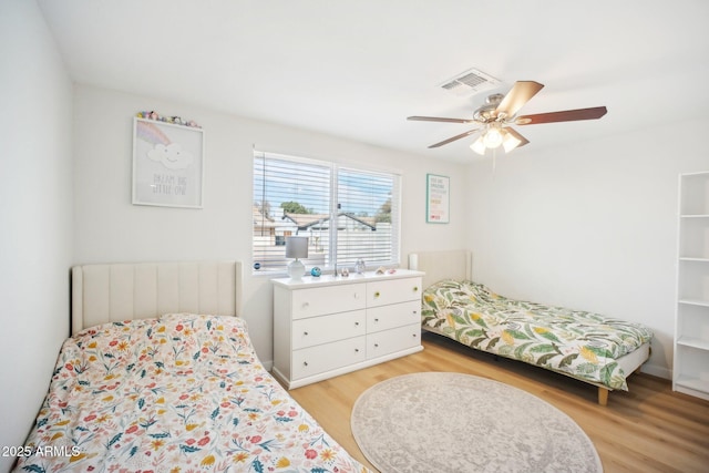 bedroom featuring light wood-type flooring, visible vents, and ceiling fan