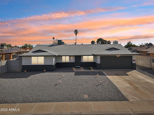 view of front of property with a garage, fence, concrete driveway, and brick siding