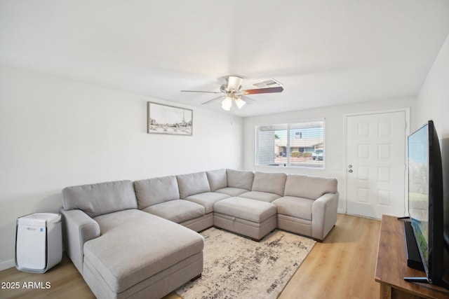 living area with ceiling fan, visible vents, and wood finished floors