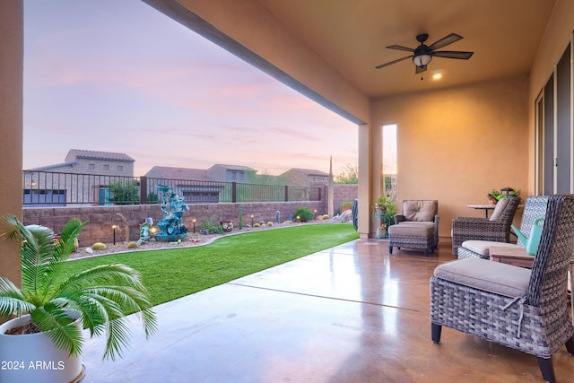 patio terrace at dusk with a lawn and ceiling fan