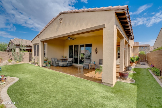 rear view of property with a patio, a yard, and ceiling fan