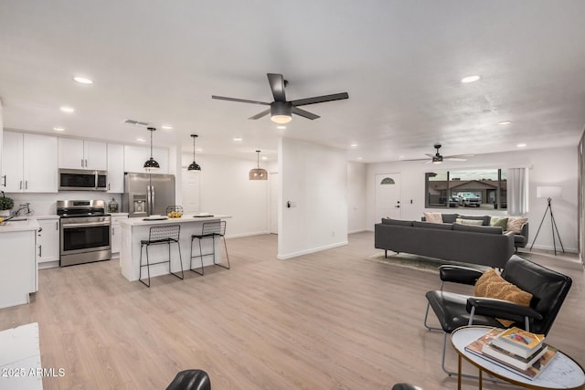 living room with light hardwood / wood-style floors and ceiling fan