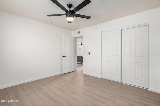 unfurnished bedroom featuring ceiling fan, a closet, and light hardwood / wood-style flooring