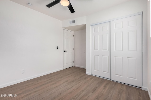 unfurnished bedroom featuring ceiling fan, light hardwood / wood-style floors, and a closet