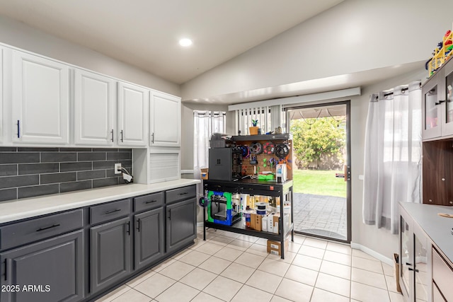 kitchen with white cabinetry, vaulted ceiling, gray cabinets, and tasteful backsplash