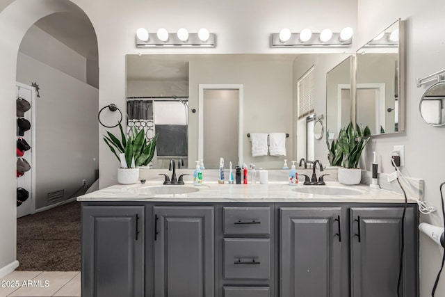 full bath with double vanity, a sink, tile patterned flooring, and visible vents