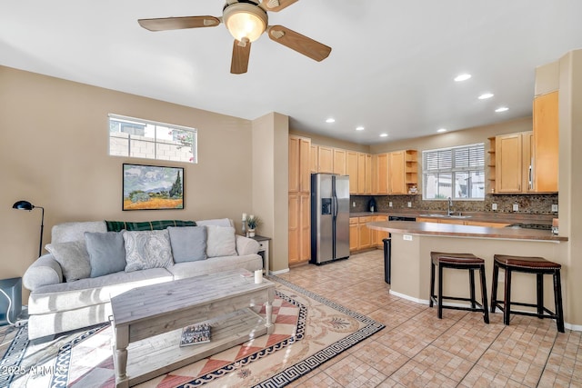 450 W Mountain Sage Dr, Phoenix, AZ 85045 - kitchen featuring stainless steel refrigerator with ice dispenser, open shelves, a sink, light brown cabinets, and a peninsula
