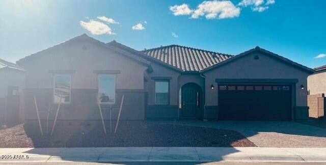 view of front of property featuring stucco siding, driveway, and a garage