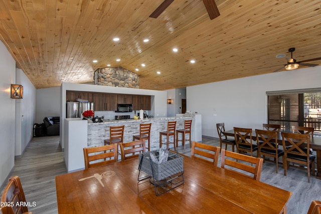 dining space with hardwood / wood-style floors, vaulted ceiling, wooden ceiling, and ceiling fan