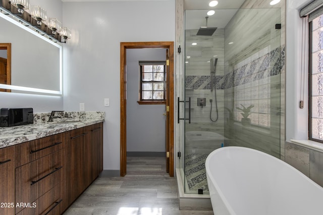 bathroom featuring hardwood / wood-style flooring, vanity, and independent shower and bath