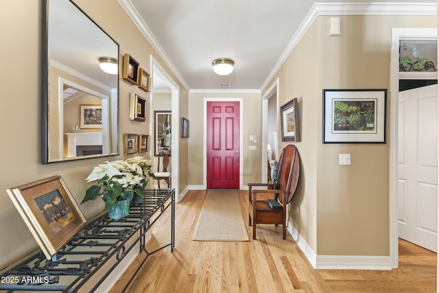 foyer entrance featuring ornamental molding and light hardwood / wood-style flooring