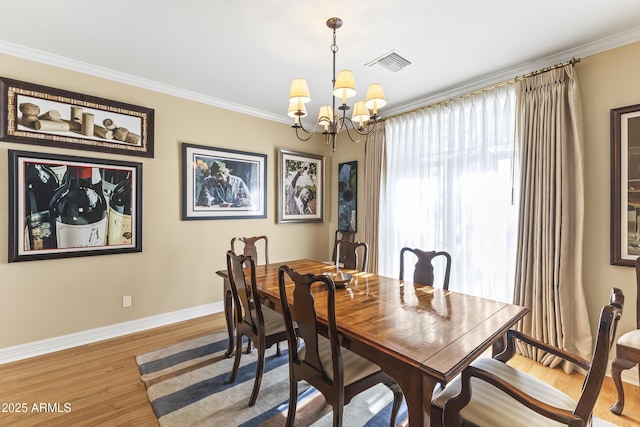 dining room featuring wood-type flooring, an inviting chandelier, and crown molding