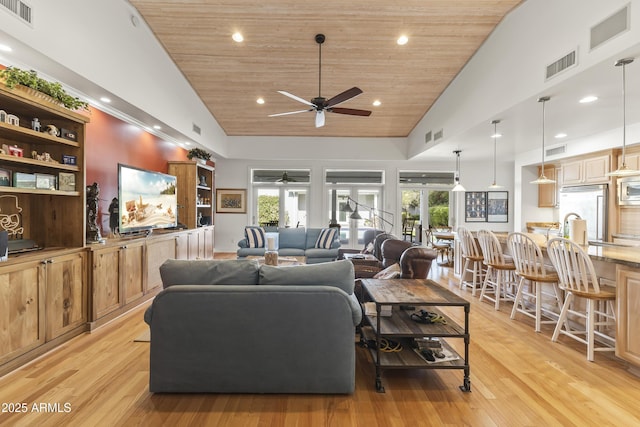 living room with light wood-type flooring, high vaulted ceiling, ceiling fan, and wooden ceiling