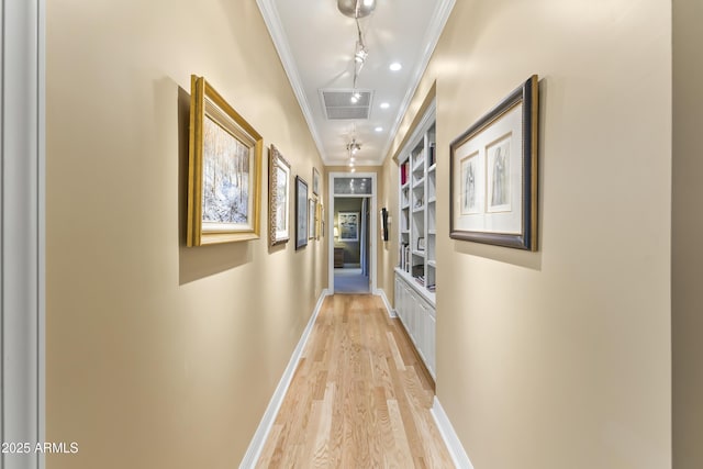 hallway with light hardwood / wood-style floors, built in features, and crown molding