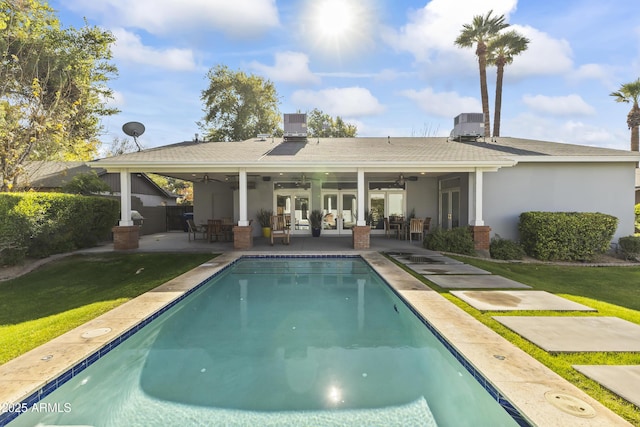 rear view of house featuring ceiling fan, cooling unit, a yard, and a patio