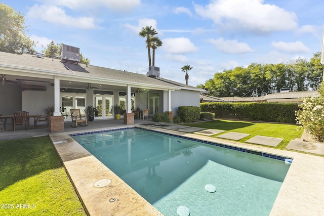 view of pool featuring french doors, a patio, central air condition unit, ceiling fan, and a yard