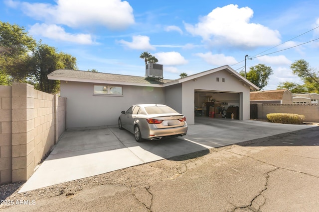 exterior space with a garage and central AC