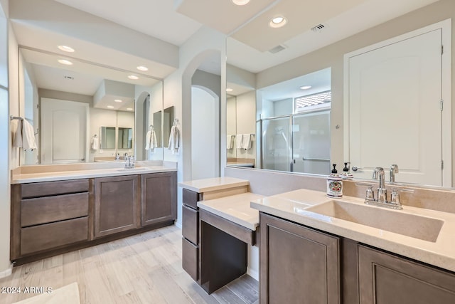 bathroom featuring hardwood / wood-style flooring, vanity, and a shower with shower door