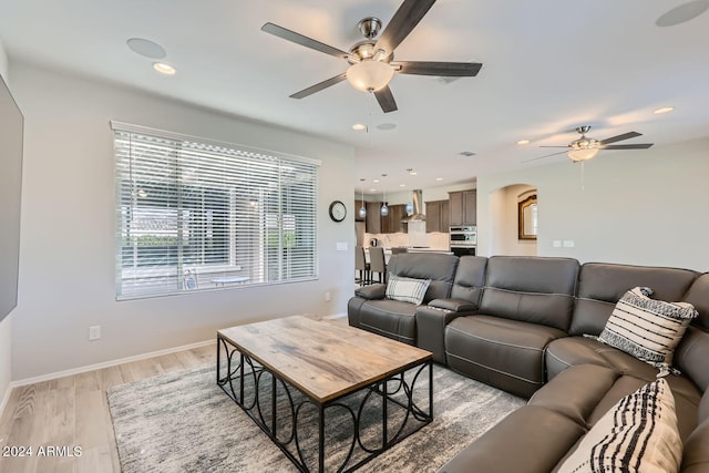 living room featuring ceiling fan and light wood-type flooring