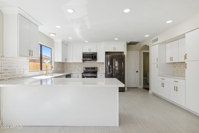 kitchen with decorative backsplash, sink, stainless steel appliances, kitchen peninsula, and white cabinets