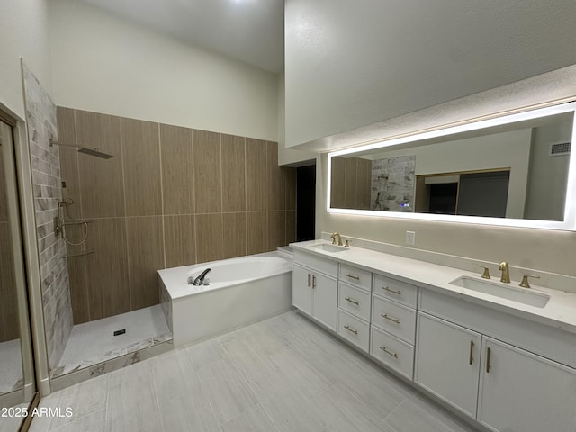 full bathroom featuring a sink, a tile shower, double vanity, and a bath