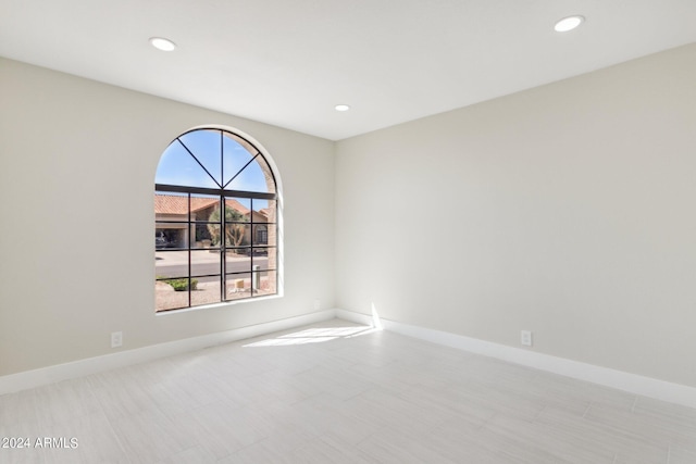 spare room with baseboards and recessed lighting