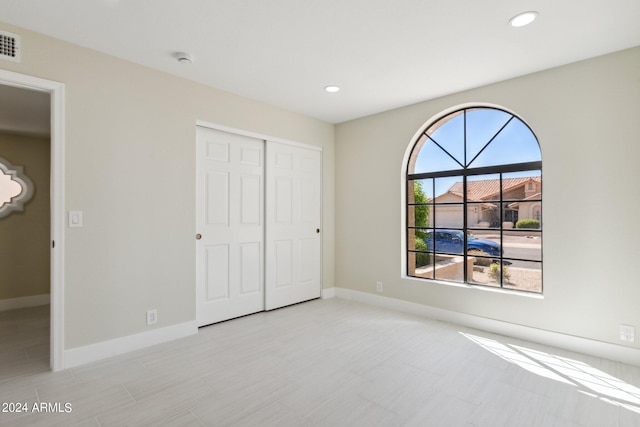 unfurnished bedroom with a closet, baseboards, visible vents, and recessed lighting