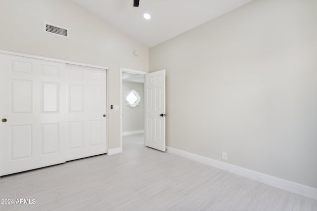 unfurnished bedroom with ceiling fan, a closet, and high vaulted ceiling