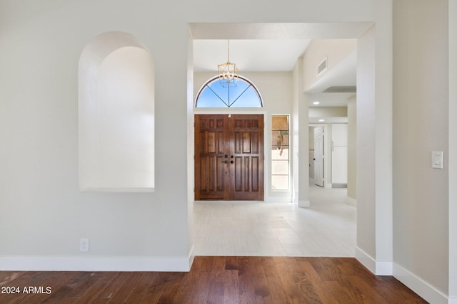 entryway featuring visible vents, baseboards, an inviting chandelier, and wood finished floors