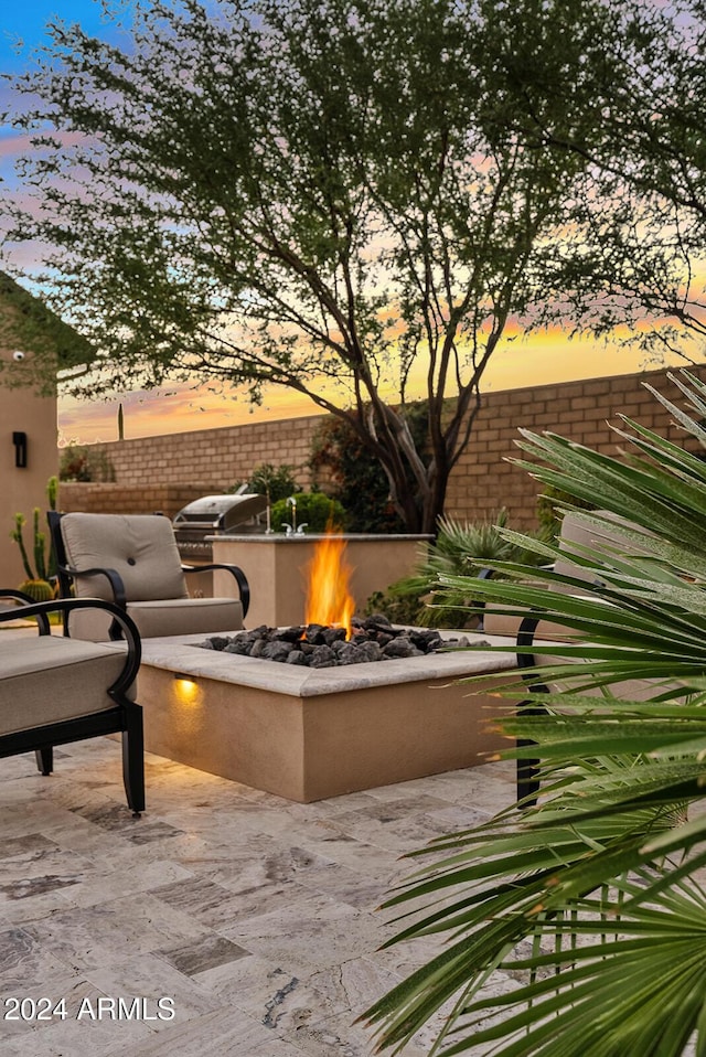 exterior space featuring a patio area, exterior kitchen, and a fire pit