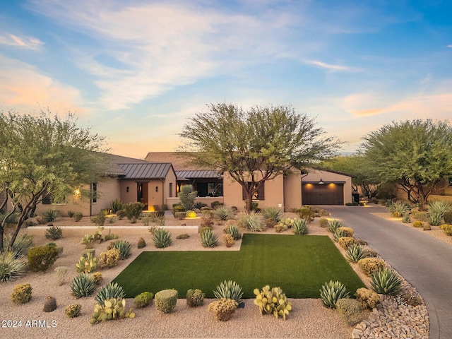 pueblo-style home featuring a yard and a garage