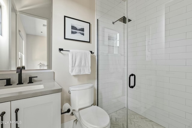 bathroom featuring an enclosed shower, vanity, and toilet