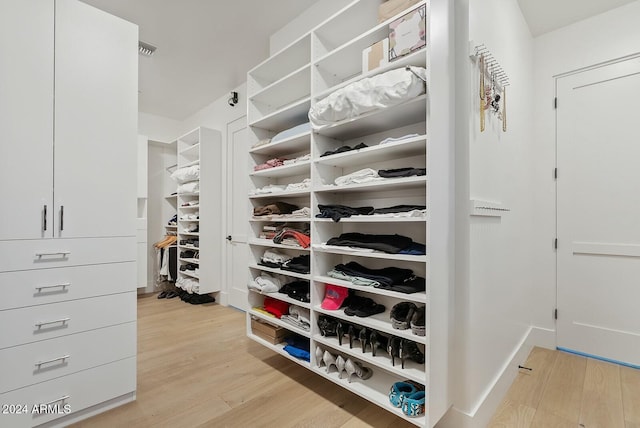 spacious closet with light hardwood / wood-style flooring