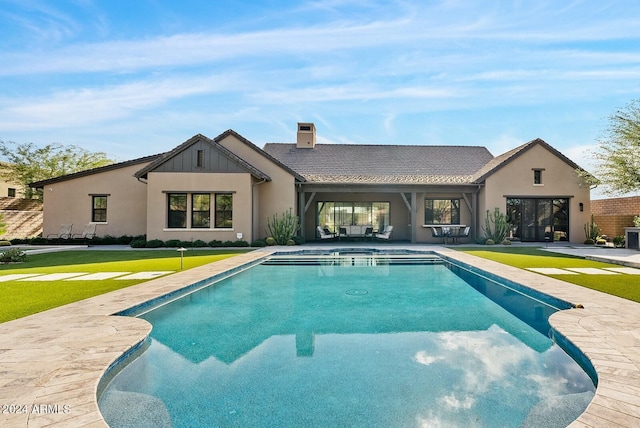 rear view of house with a yard and a patio