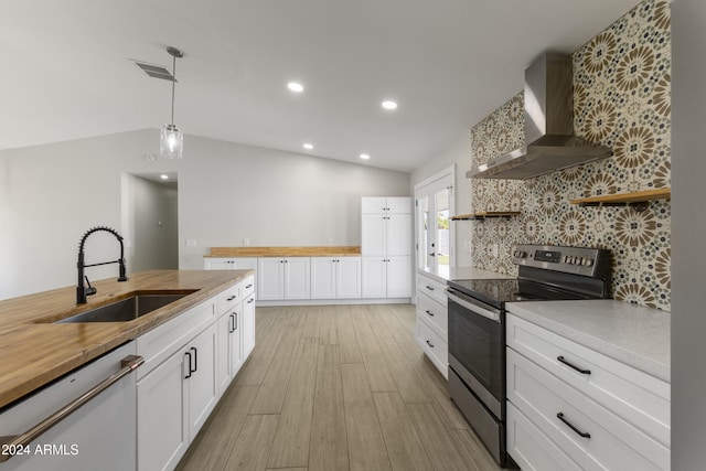 kitchen featuring pendant lighting, sink, white cabinets, stainless steel appliances, and wall chimney range hood