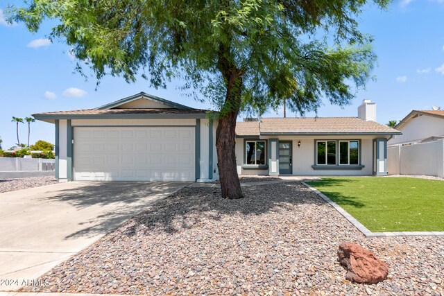 single story home featuring a garage and a front yard