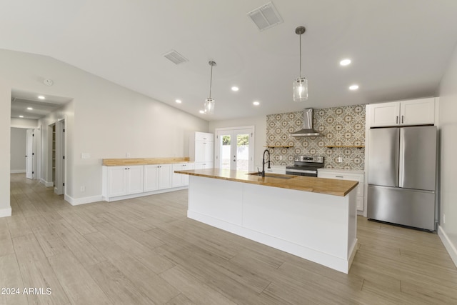 kitchen featuring stainless steel appliances, white cabinetry, sink, and wall chimney range hood