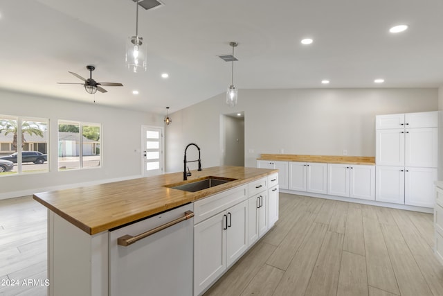 kitchen featuring light wood-type flooring, sink, lofted ceiling, and white cabinetry