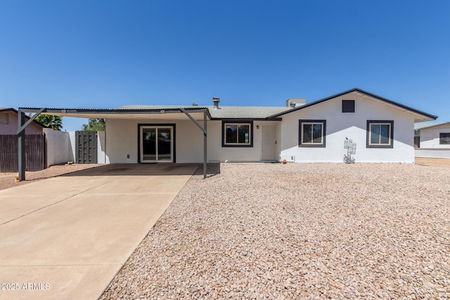 single story home with fence, stucco siding, and concrete driveway